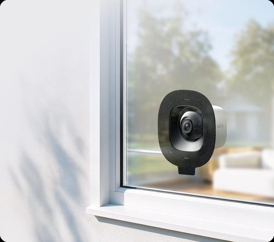 Window Camera E10 attached to the inside of a window overlooking a garden